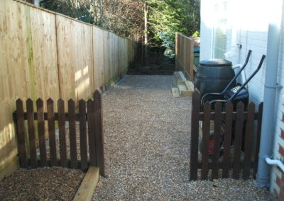 Image of small wooden picket fence with pebble floor